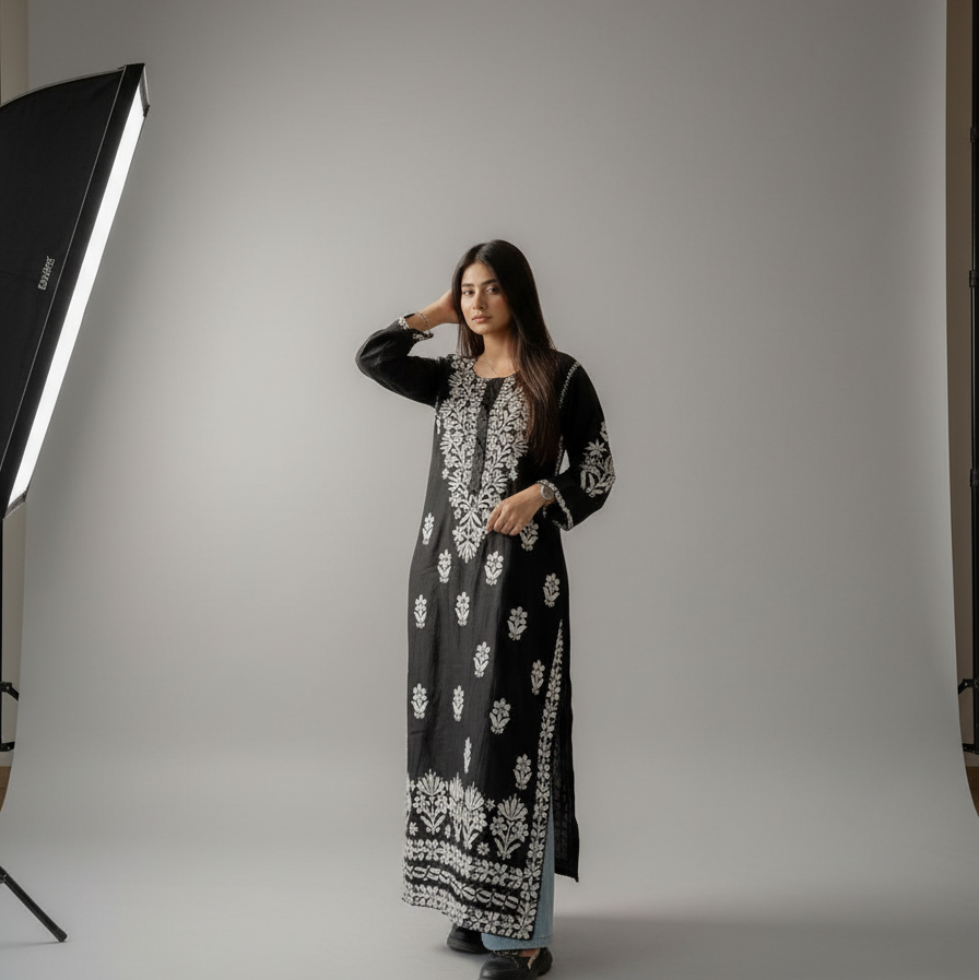 Woman in a black and white patterned outfit standing on a marble floor.