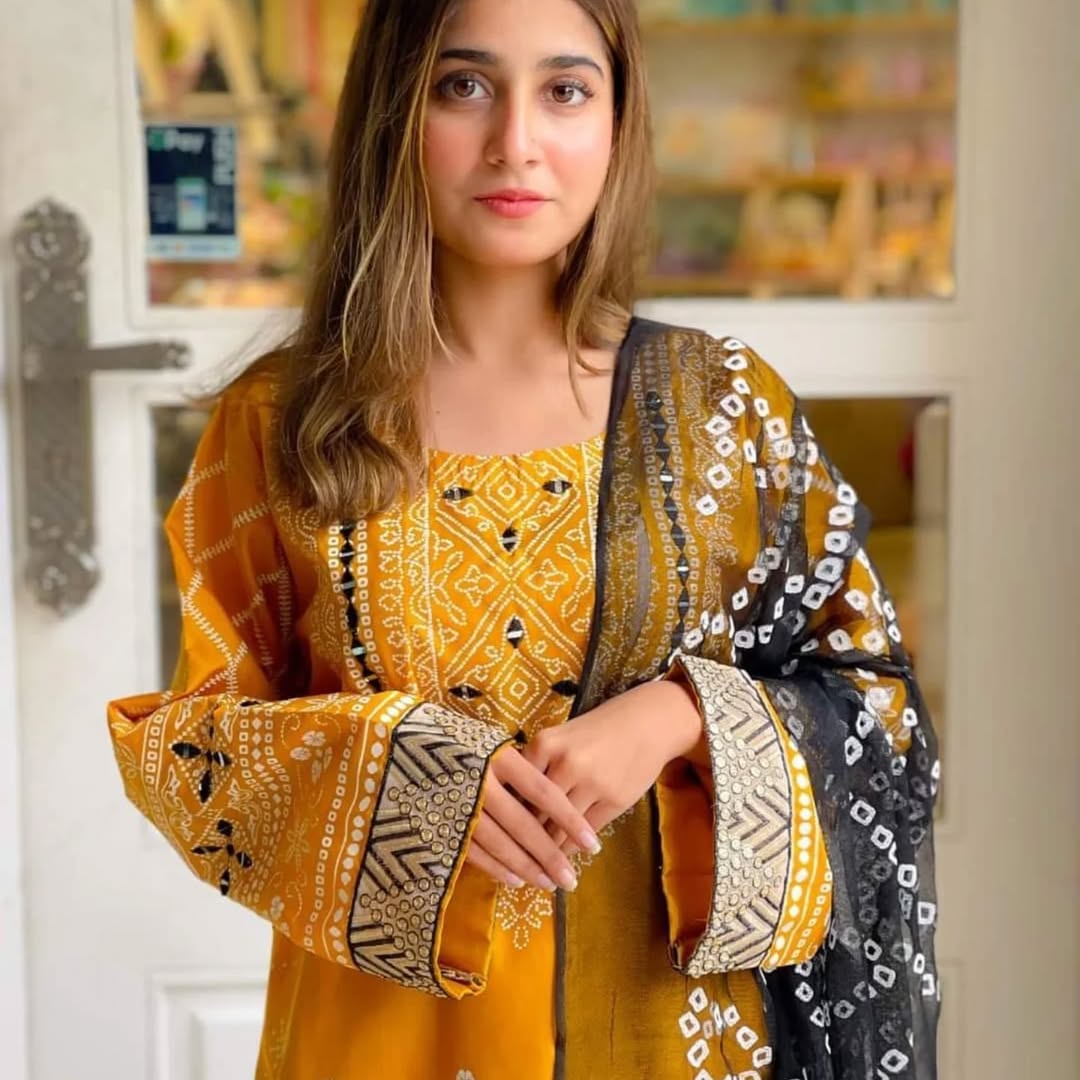 Woman wearing a yellow and black patterned outfit indoors