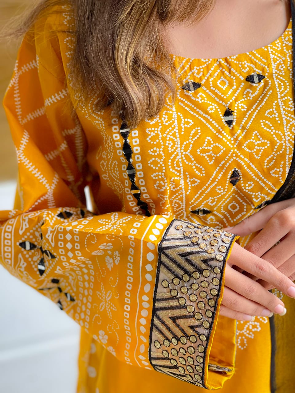 Yellow traditional outfit with intricate patterns on a blurred background